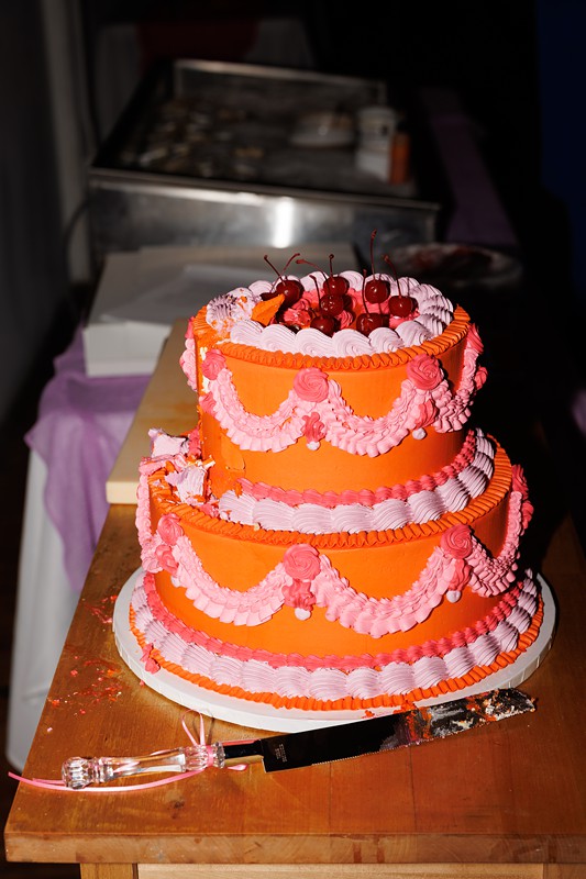 an orange and pink wedding cake at le loft