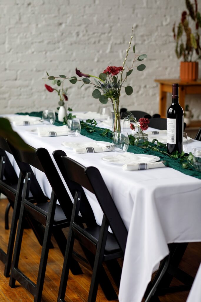 wedding table with white linens and black chairs
