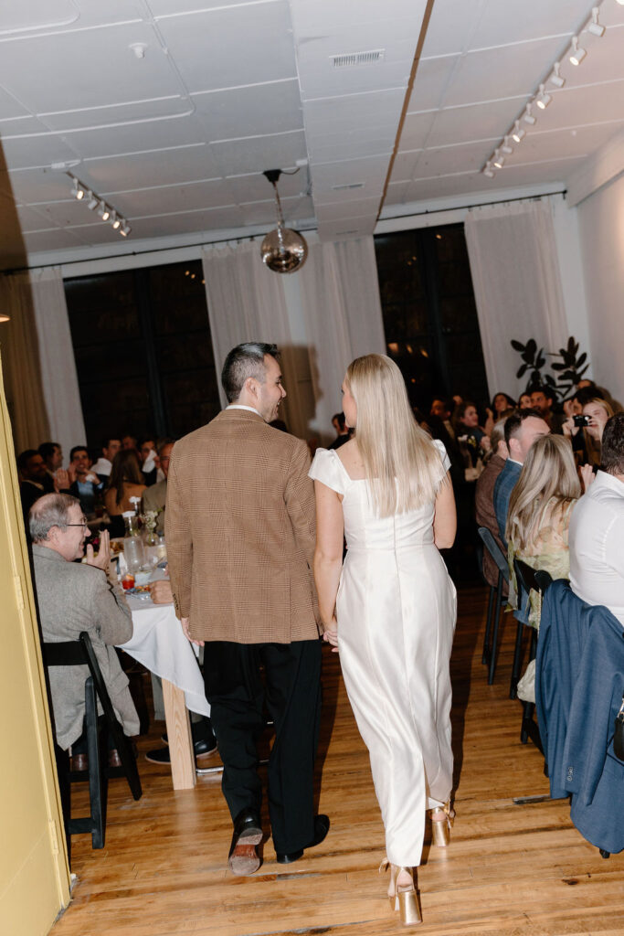 a wedding couple makes their grand entrance into their reception at Le Loft, a chicago venue with hardwood floors. 