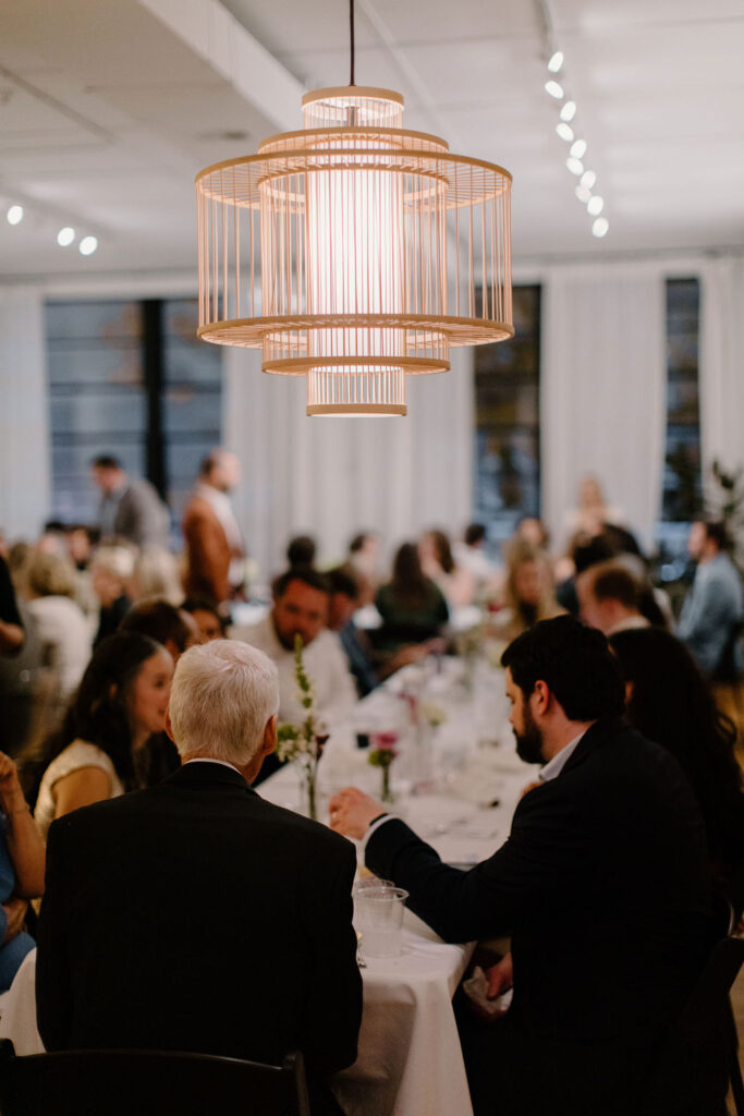 Tiered sculptural pendant light hanging above wedding reception dinner at Le Loft Chicago