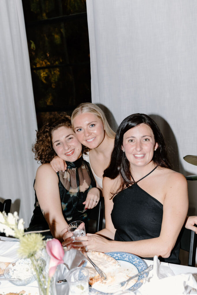 Three women smiling and celebrating together at a wedding reception at Le Loft Chicago