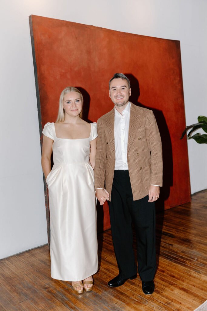 Wedding couple standing in front of a large red artwork panel on hardwood floors at Le Loft Chicago