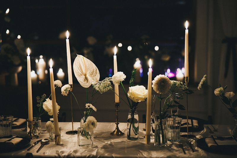 a table is set with bud vases and white candles for an intimate dinner party at le loft a wicker park venue