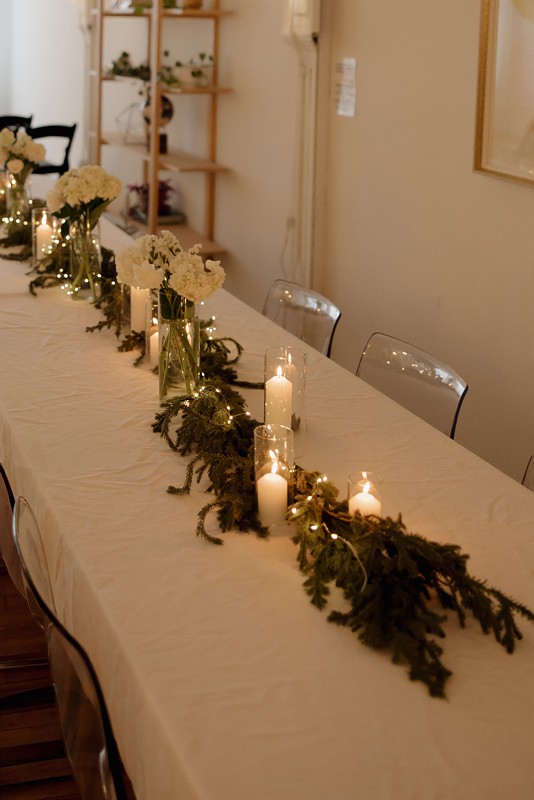 A Chicago loft event space set up for a corporate holiday party with warm lighting and a long dining table.